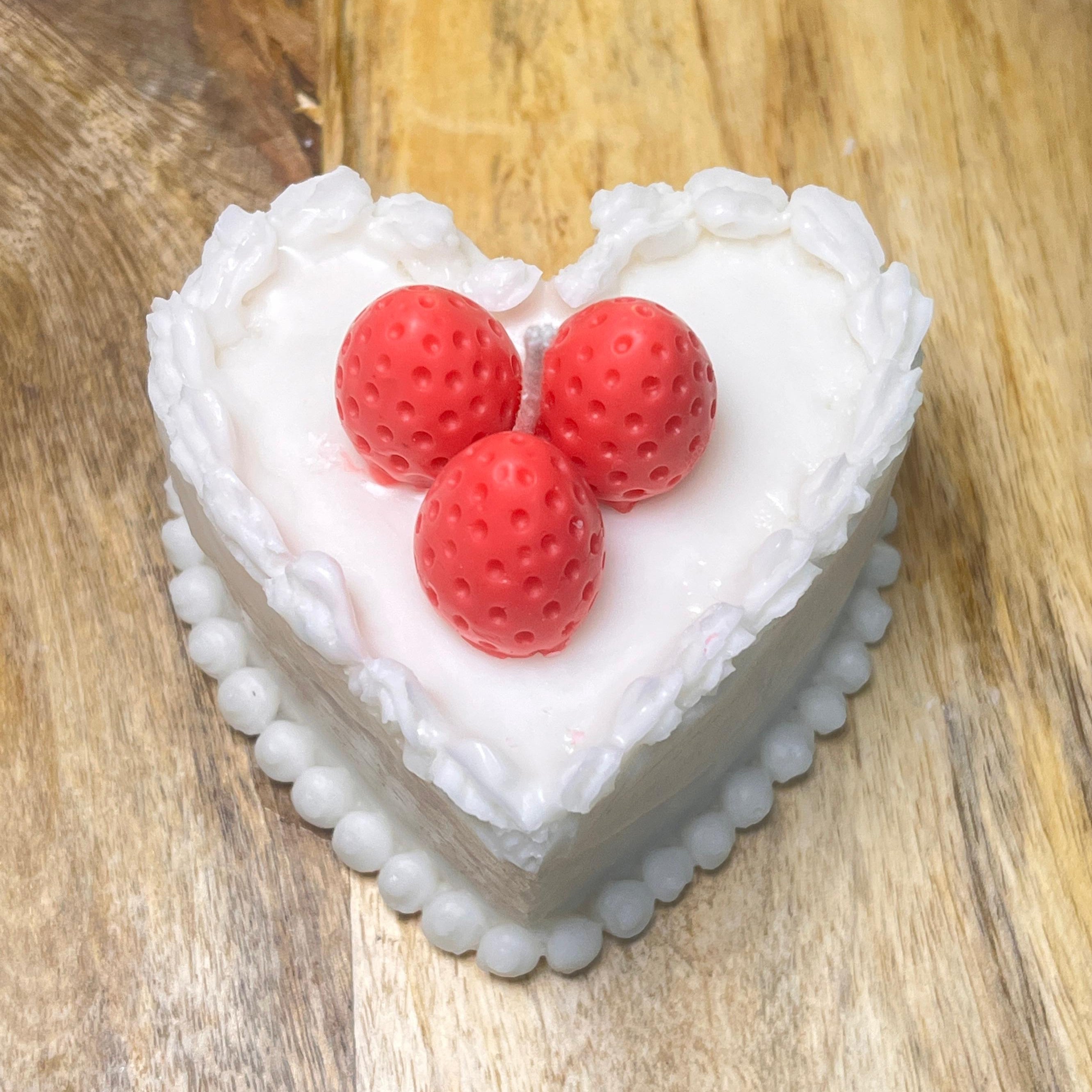 Heart-shaped cake with white frosting and red strawberries 
